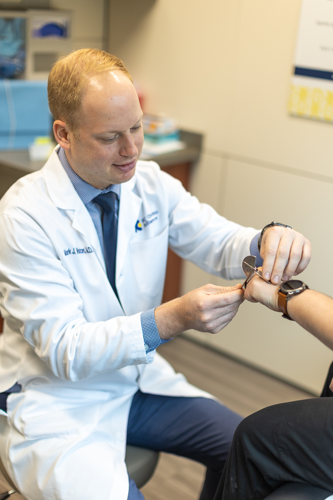 Dr. Mark Winston examining a patient's hand